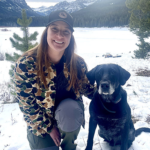 Rebecca Rebrovich with her dog in the snow mountains